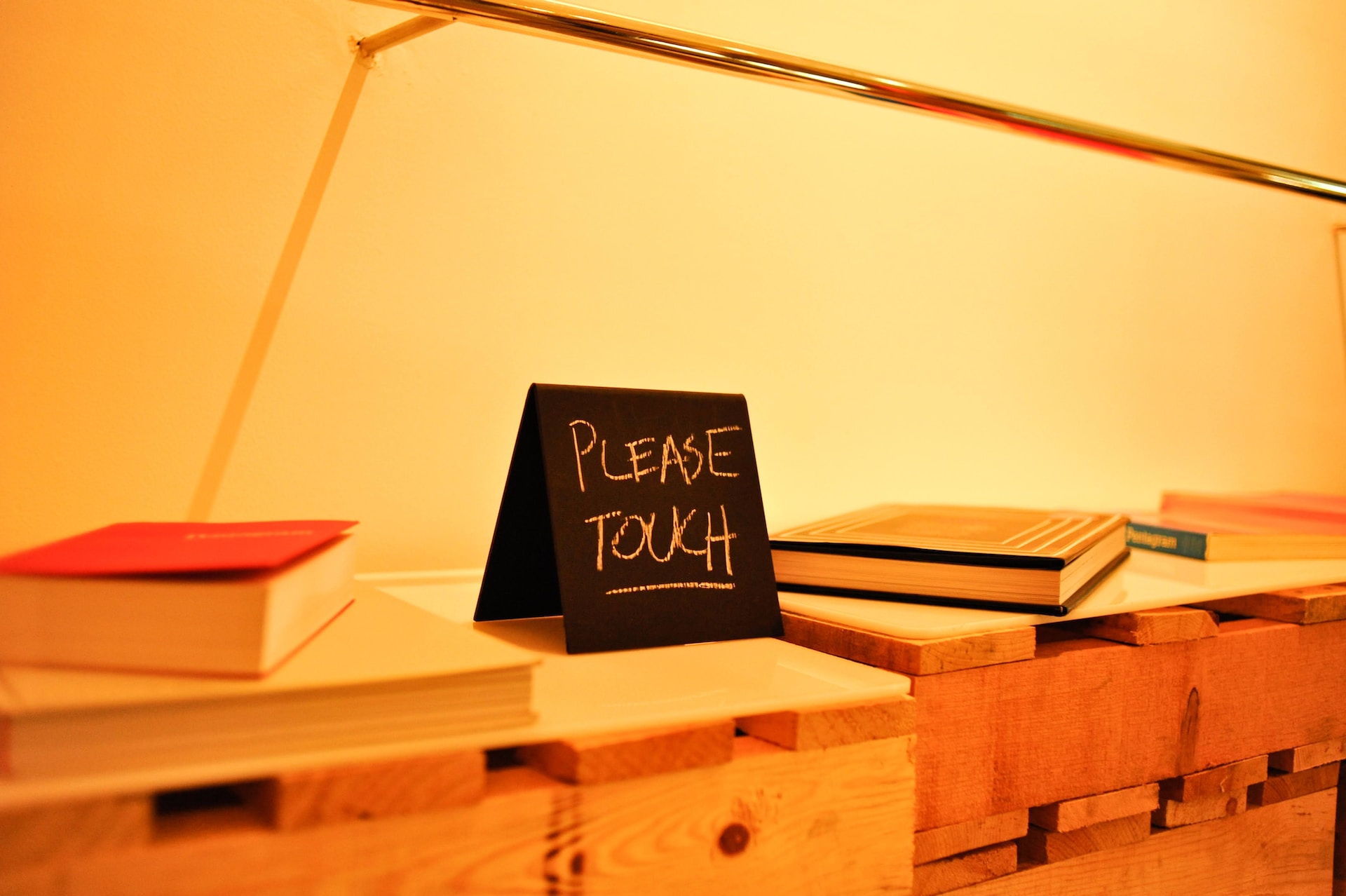 brown wooden table with a sign on top that says please touch