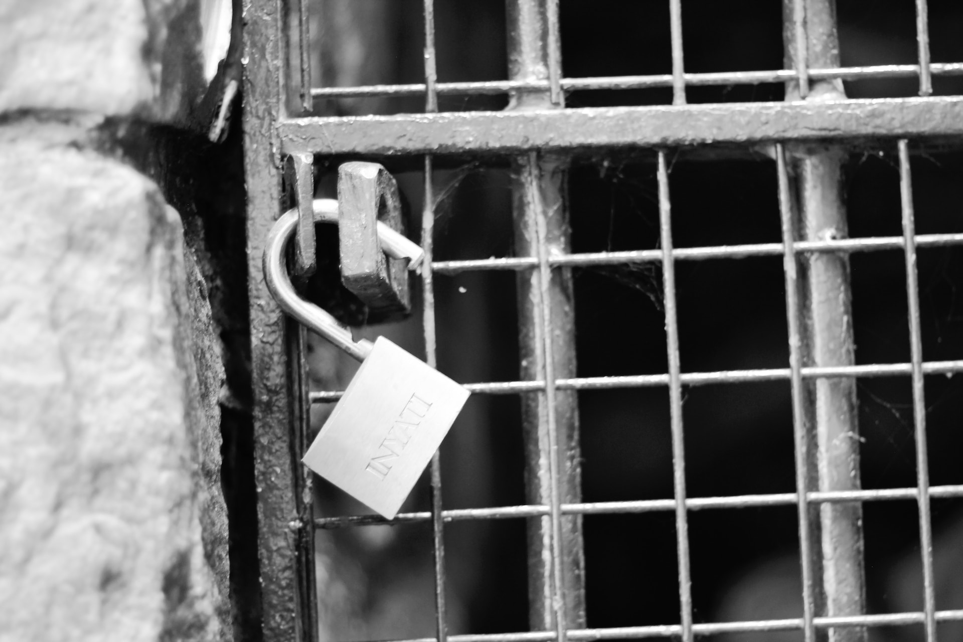 open padlock on metal gate during daytime